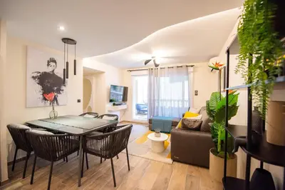 a dining room and living room with a table and chairs at Palazzio T3 design près des plages et du Palais in Cannes
