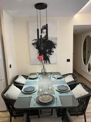a dining room with a table with chairs and a vase with a flower at Palazzio T3 design près des plages et du Palais in Cannes