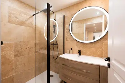 a bathroom with a shower and a sink and a mirror at Palazzio T3 design près des plages et du Palais in Cannes