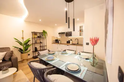 a living room with a dining room table with chairs at Palazzio T3 design près des plages et du Palais in Cannes