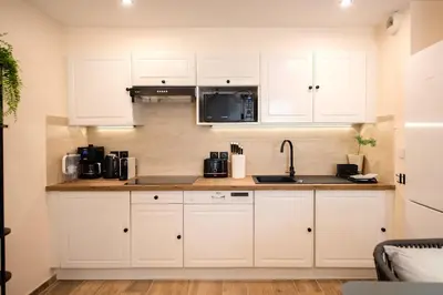 a kitchen with white cabinets and a microwave at Palazzio T3 design près des plages et du Palais in Cannes