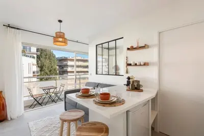 a kitchen with a white counter and a large window at Appartement Cannes 1 chambre - QG in Cannes
