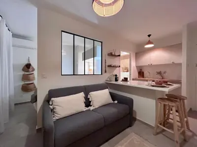 a living room with a couch and a kitchen at Appartement Cannes 1 chambre - QG in Cannes
