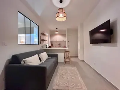 a living room with a couch and a kitchen at Appartement Cannes 1 chambre - QG in Cannes