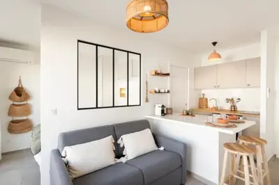 a living room with a couch and a kitchen at Appartement Cannes 1 chambre - QG in Cannes