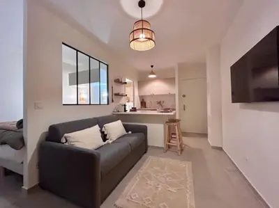 a living room with a couch and a kitchen at Appartement Cannes 1 chambre - QG in Cannes