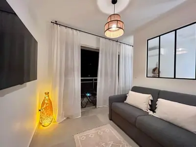 a living room with a couch and a large window at Appartement Cannes 1 chambre - QG in Cannes