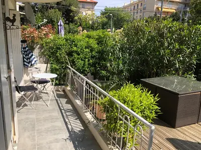 a balcony with a table and chairs and plants at Only 60m to the beach, 2 bedroom cozy apartment, 80m2 big garden, very central in Cannes