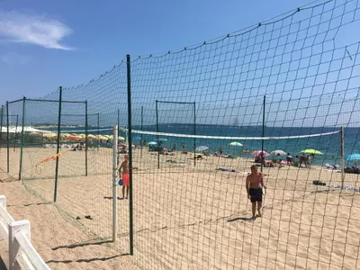 a volley ball net on a beach with people at Only 60m to the beach, 2 bedroom cozy apartment, 80m2 big garden, very central in Cannes