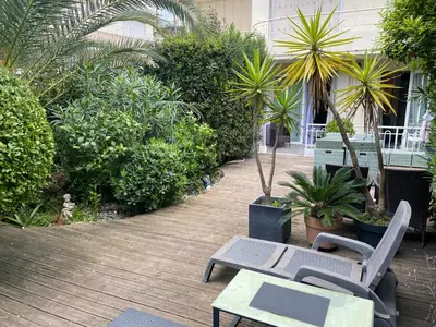 a patio with chairs and a table and plants at Only 60m to the beach, 2 bedroom cozy apartment, 80m2 big garden, very central in Cannes