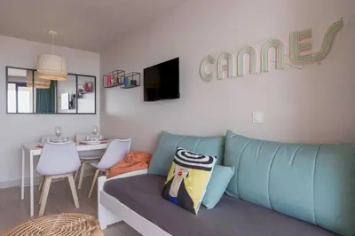 a living room with a blue couch and a table at Bella Vista - Piscine, vue mer, parking, clim in Cannes