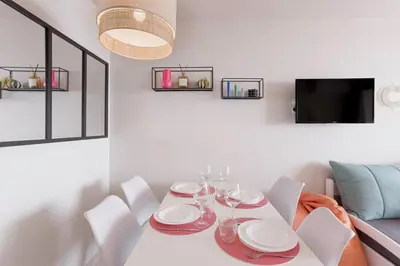 a white dining room with a table and chairs at Bella Vista - Piscine, vue mer, parking, clim in Cannes