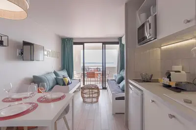 a kitchen and living room with a couch and a table at Bella Vista - Piscine, vue mer, parking, clim in Cannes