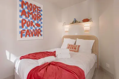 a bedroom with a bed with a red blanket on it at Bella Vista - Piscine, vue mer, parking, clim in Cannes