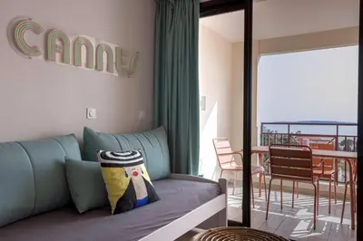 a living room with a couch and a balcony at Bella Vista - Piscine, vue mer, parking, clim in Cannes