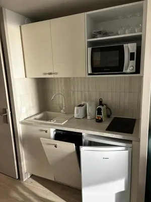 a kitchen with white cabinets and a microwave at Villa Francia Cannes in Cannes