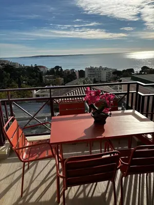 a table with a vase of flowers on a balcony at Villa Francia Cannes in Cannes