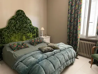 a bedroom with a large bed with a large headboard at Chez Nicole in Cannes