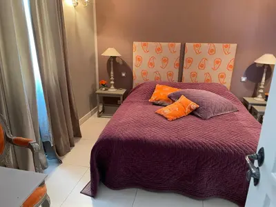 a bedroom with a purple bed with two orange pillows at Chez Nicole in Cannes