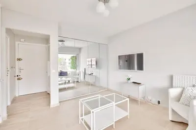 a white living room with a white couch and a table at Superbe studio avec terrasse à 10 min de la plage in Cannes