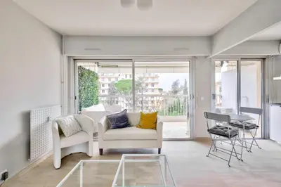 a living room with a white couch and a table at Superbe studio avec terrasse à 10 min de la plage in Cannes