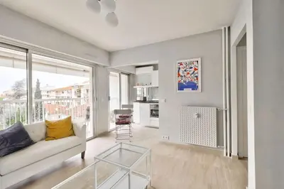 a living room with a couch and a glass table at Superbe studio avec terrasse à 10 min de la plage in Cannes