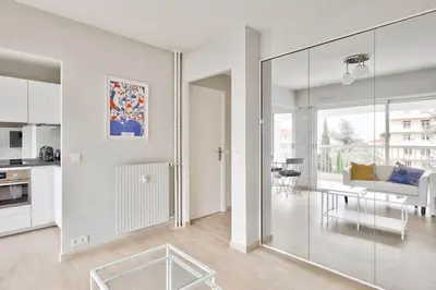 a white living room with a glass wall at Superbe studio avec terrasse à 10 min de la plage in Cannes