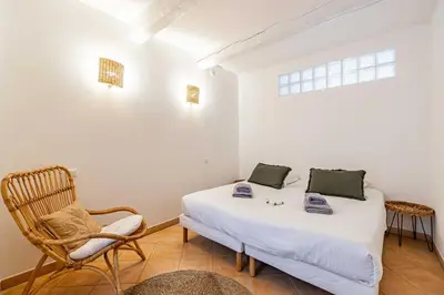 a bedroom with a bed and a chair and a window at Charming apartment heart of Le Suquet in Cannes