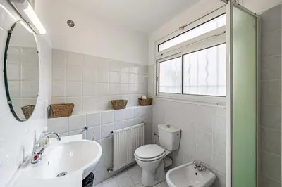 a white bathroom with a toilet and a sink at Charming apartment heart of Le Suquet in Cannes