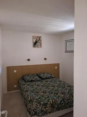 a bedroom with a bed in a white room at Appartement 3 pièces, proche plage et cannes in Cannes