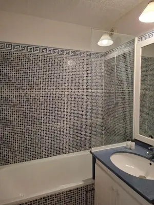 a bathroom with a sink and a tub and a mirror at Appartement 3 pièces, proche plage et cannes in Cannes