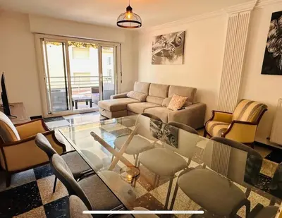 a living room with a glass table and chairs at Appartement Veronica in Cannes