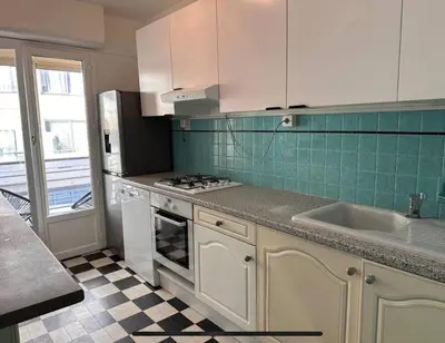 a kitchen with white cabinets and a stove and a sink at Appartement Veronica in Cannes