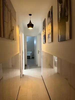 a hallway with a tile floor and paintings on the walls at Appartement Veronica in Cannes