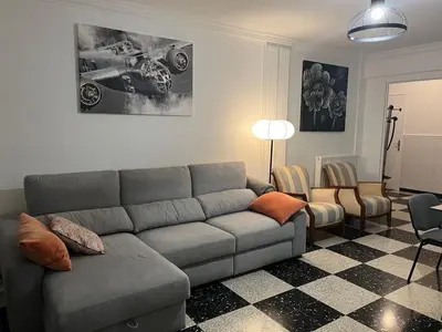 a living room with a gray couch and a checkerboard floor at Appartement Veronica in Cannes