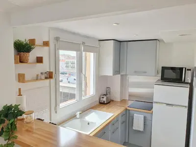 a white kitchen with a sink and a window at Studio hyper centre Cannes - Tout à pied in Cannes