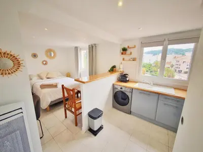a bedroom with a bed and a kitchen with a sink at Studio hyper centre Cannes - Tout à pied in Cannes