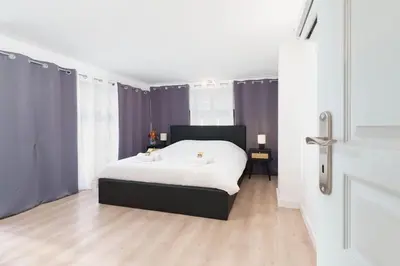 a bedroom with a white bed and purple curtains at Le Val By ApiRent #Duplex #Climatisation in Le Cannet