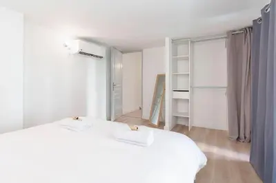 a white bedroom with two beds and a window at Le Val By ApiRent #Duplex #Climatisation in Le Cannet