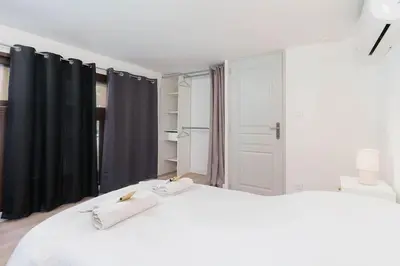 a bedroom with a white bed with black curtains at Le Val By ApiRent #Duplex #Climatisation in Le Cannet
