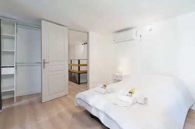 a white bedroom with a bed and a mirror at Le Val By ApiRent #Duplex #Climatisation in Le Cannet
