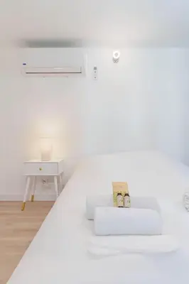 a white room with a white bed and a table at Le Val By ApiRent #Duplex #Climatisation in Le Cannet