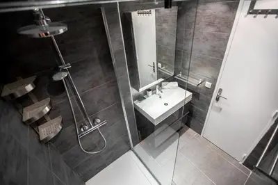 a bathroom with a shower and a sink and a mirror at Comfort 6 People Apartment by Connexion in Cannes