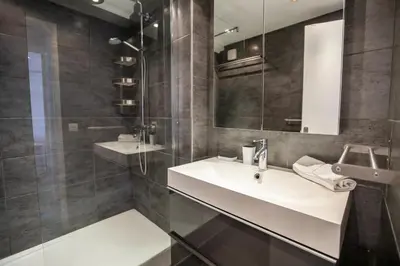 a bathroom with a sink and a shower and a mirror at Comfort 6 People Apartment by Connexion in Cannes