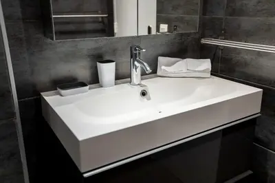 a bathroom with a white sink and a mirror at Comfort 6 People Apartment by Connexion in Cannes