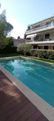 a blue swimming pool in front of a building at Les Jardins de Louis in Cannes