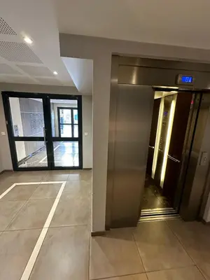 a lobby with an elevator in a building at Les Jardins de Louis in Cannes