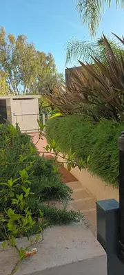 a walkway with plants and a building in the background at Les Jardins de Louis in Cannes