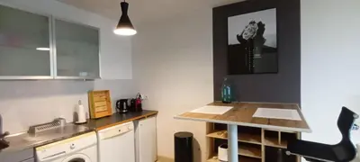 a kitchen with a counter and a table in it at Les Jardins de Louis in Cannes