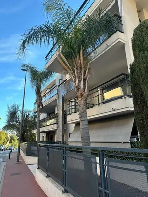 a palm tree in front of a building at Les Jardins de Louis in Cannes